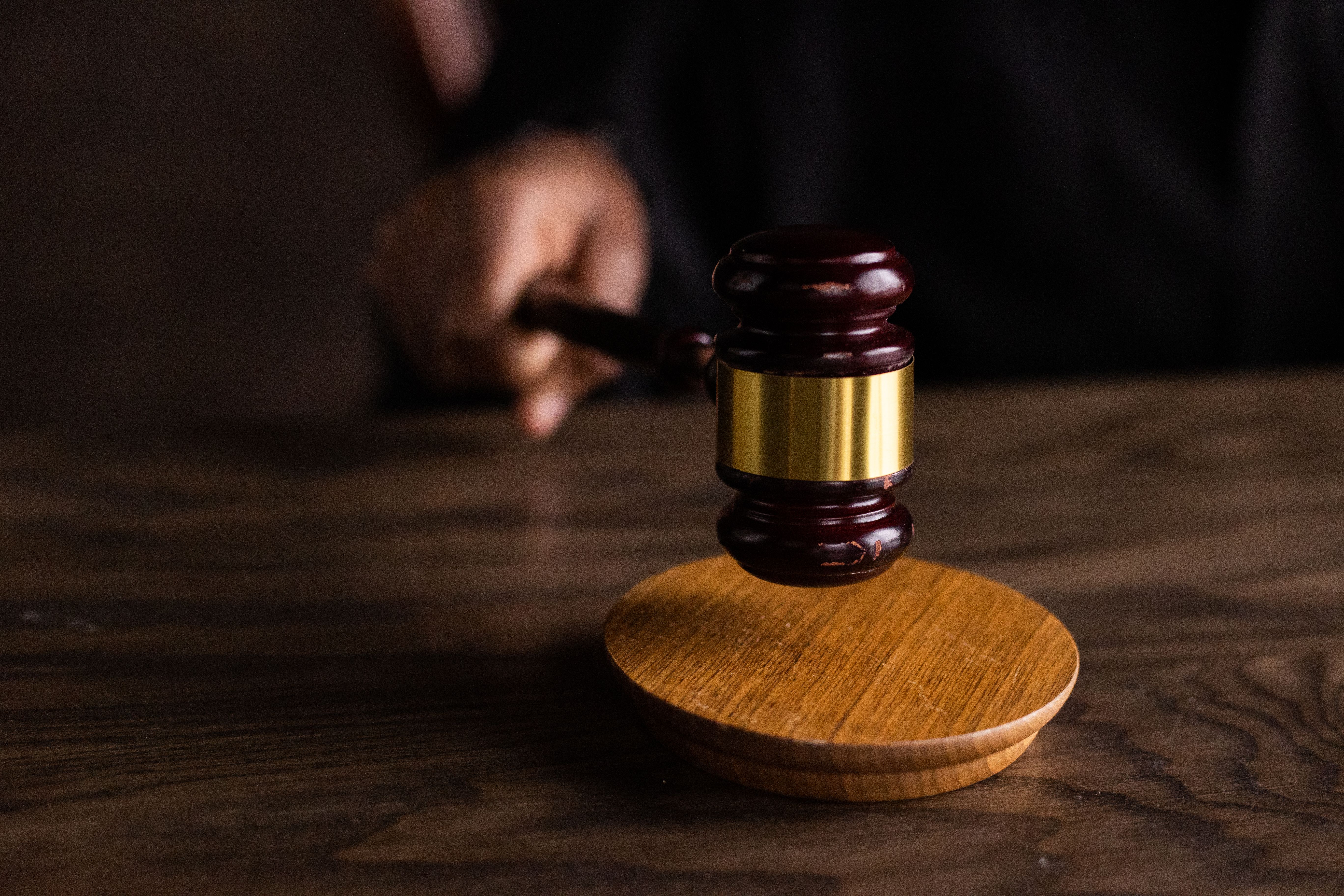 Judge's gavel striking a sound block in a courtroom, symbolizing a lawsuit verdict