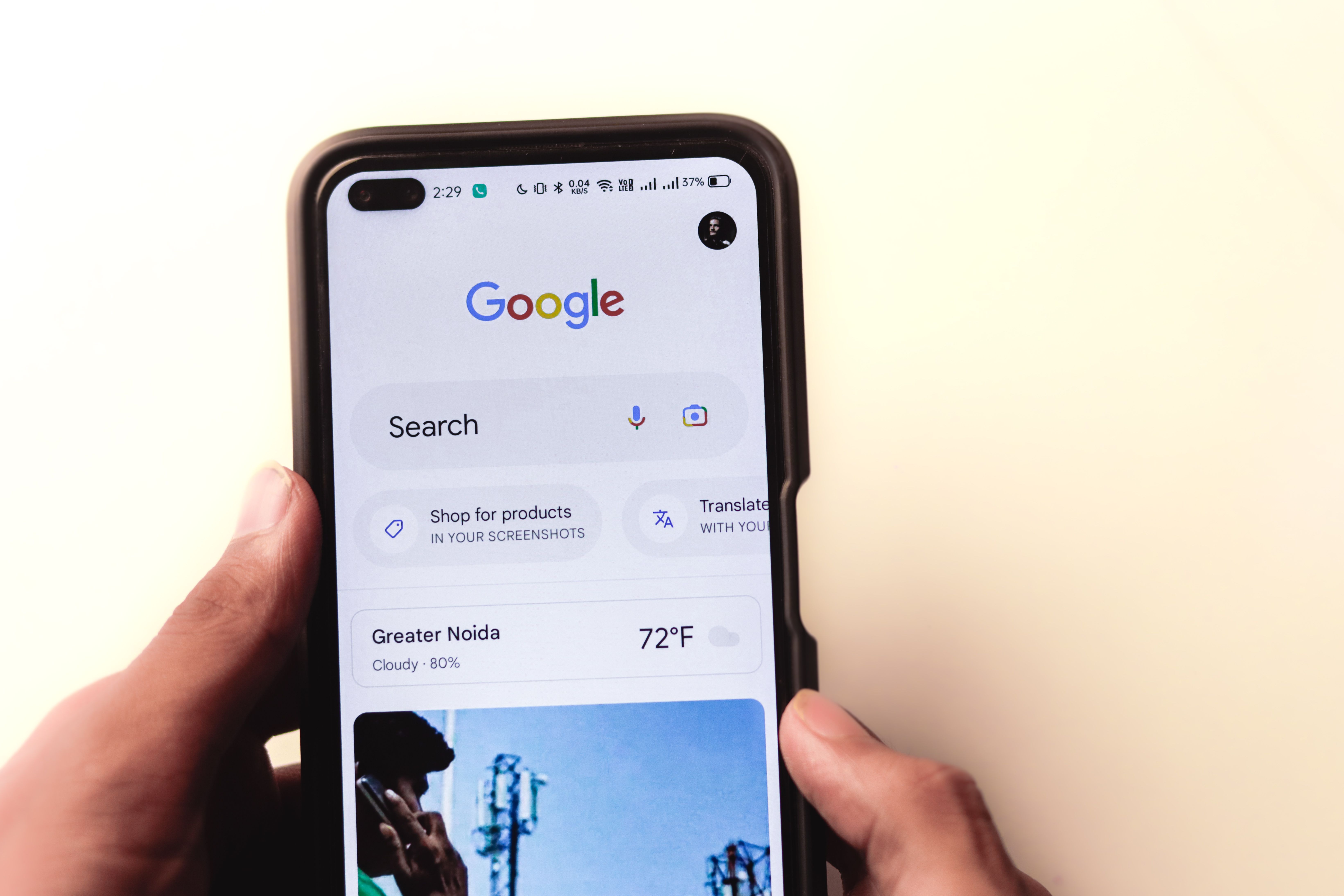 Hand holding a smartphone displaying the Google search page