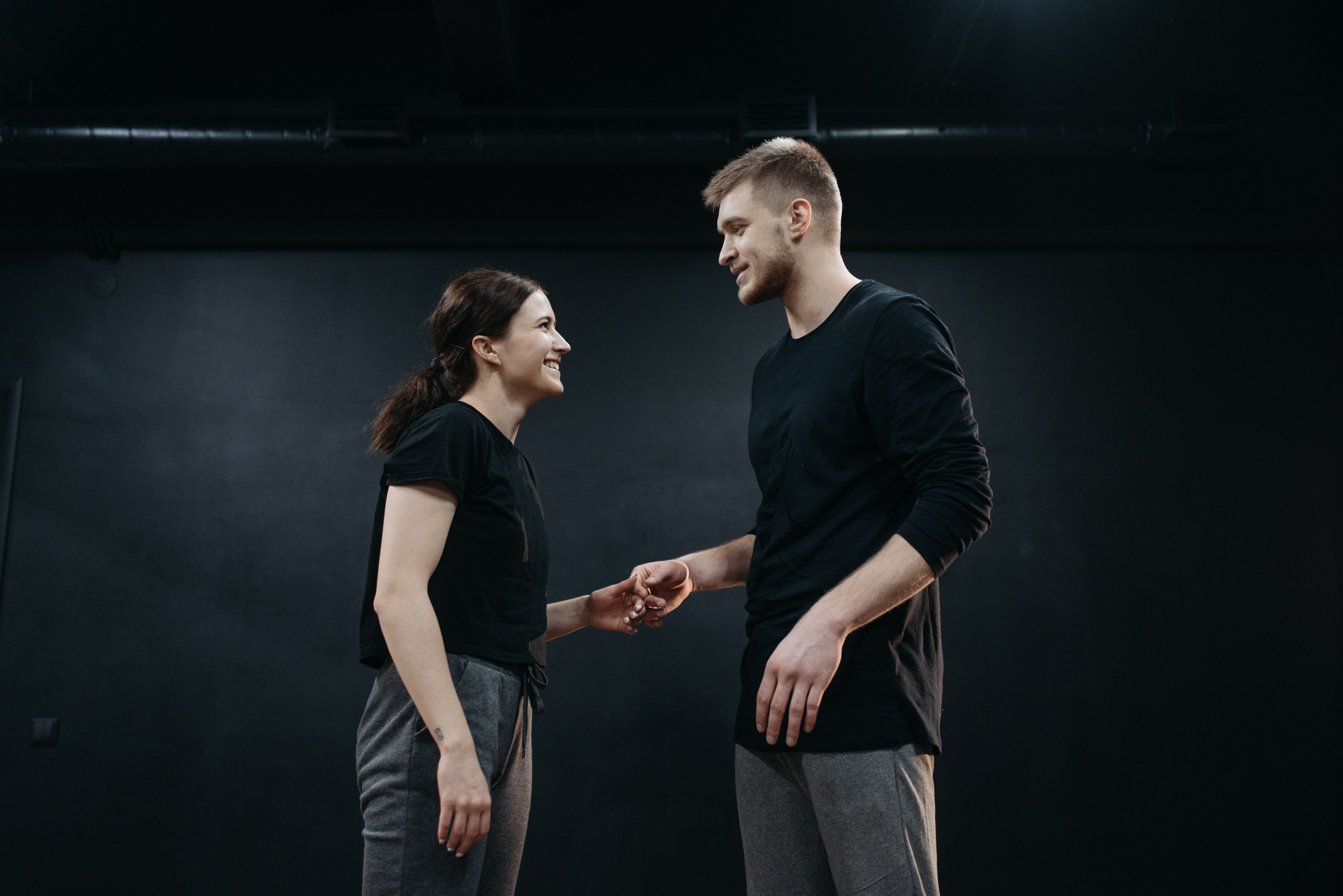 Two people smile at each other, showing warm eye contact and open body language.