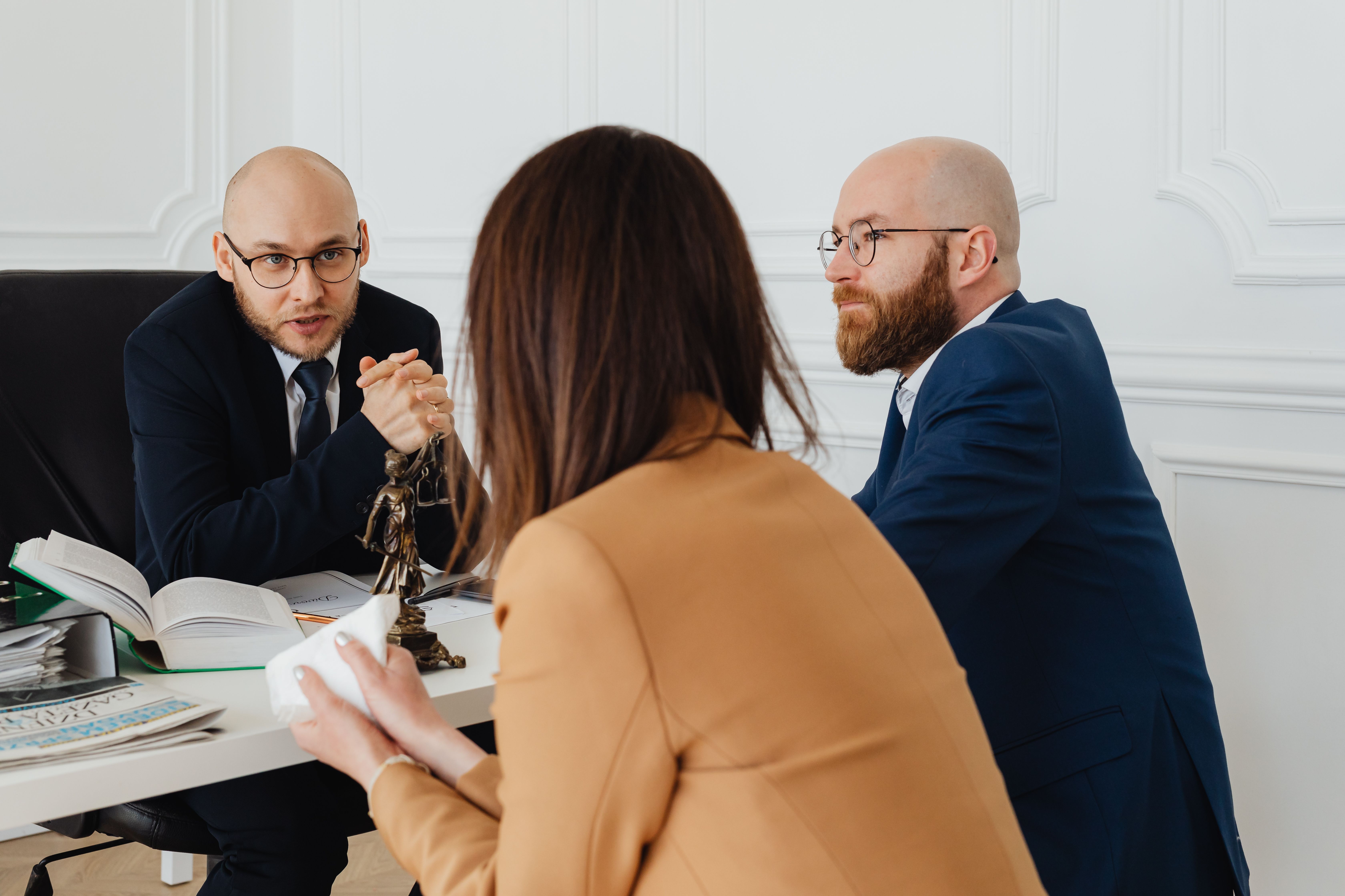 Lawyers discussing a case in a modern office, representing legal strategy and client counsel.