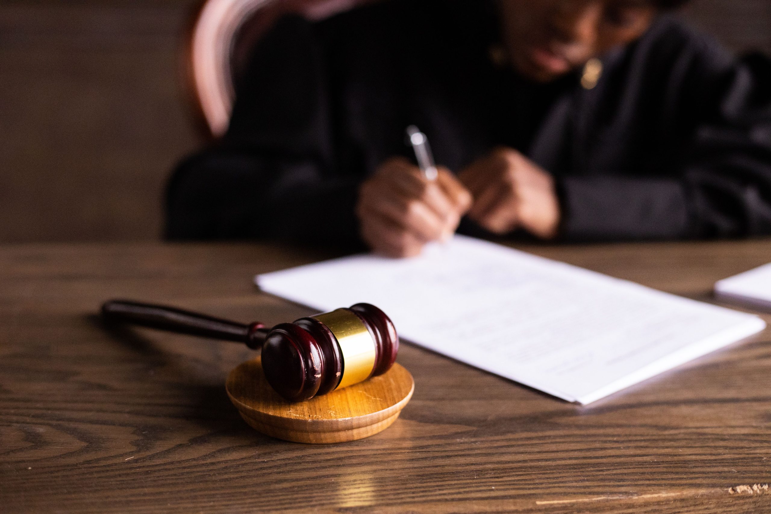 Judge signing legal documents beside a gavel, representing litigation and the justice system.